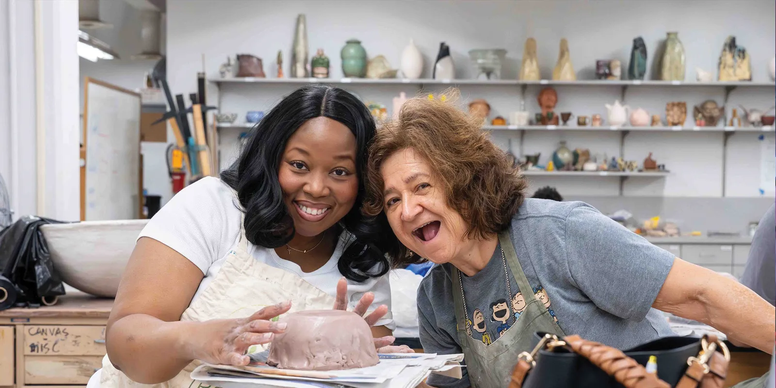 Friends smile as they learn how to make a clay bowl in the Lee College ceramics studio.