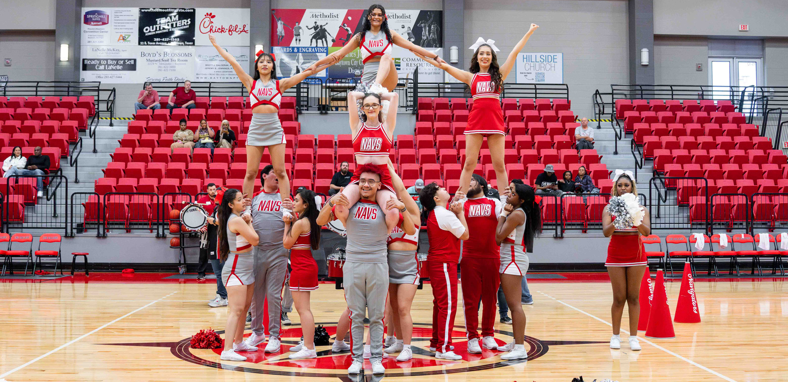 The cheer team forms a pyramid in the arena.